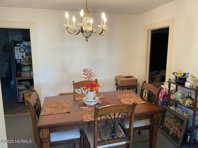 dining room with a chandelier and crown molding