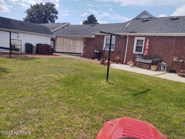 exterior space with a front lawn, roof with shingles, and brick siding