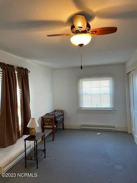 sitting room featuring a baseboard radiator, a ceiling fan, and carpet flooring