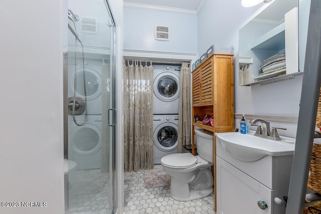 bathroom with tile patterned floors, vanity, crown molding, stacked washer / drying machine, and a shower with shower door