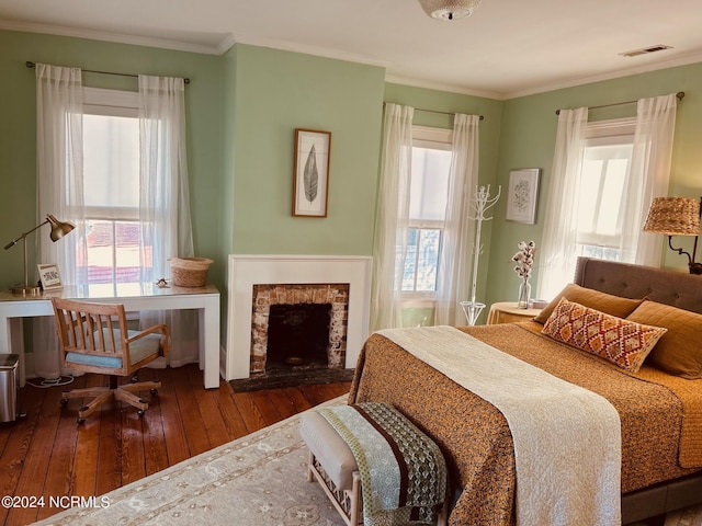 bedroom featuring dark hardwood / wood-style flooring, a brick fireplace, multiple windows, and ornamental molding