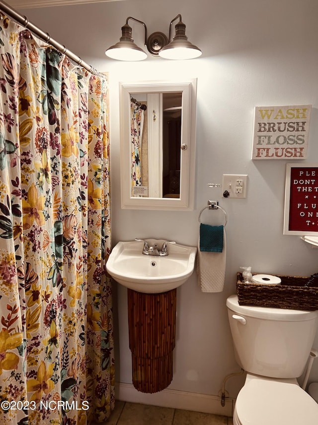 bathroom with tile patterned floors, a shower with shower curtain, and toilet