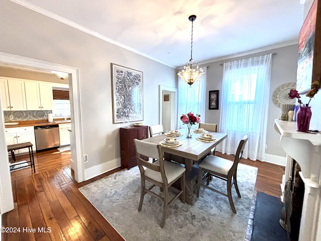 dining room featuring dark hardwood / wood-style flooring, crown molding, and a chandelier