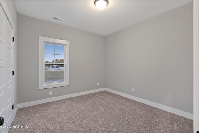 unfurnished room featuring light colored carpet