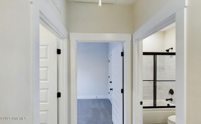 full bath featuring  shower combination, toilet, and baseboards