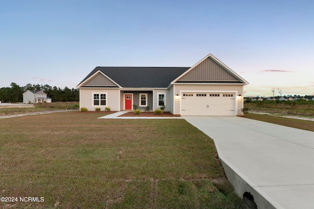 view of front of property with a yard and a garage