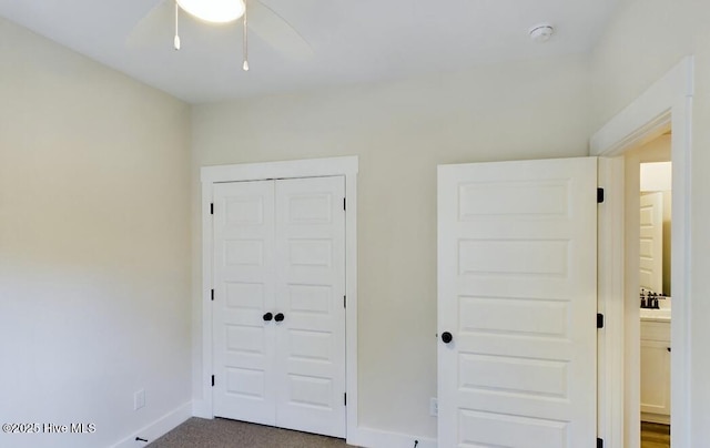 unfurnished bedroom featuring baseboards, a closet, and carpet flooring