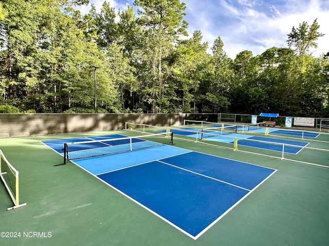 view of tennis court with community basketball court and fence