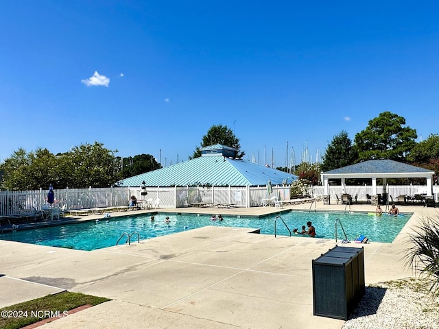 community pool featuring a gazebo, a patio, and fence