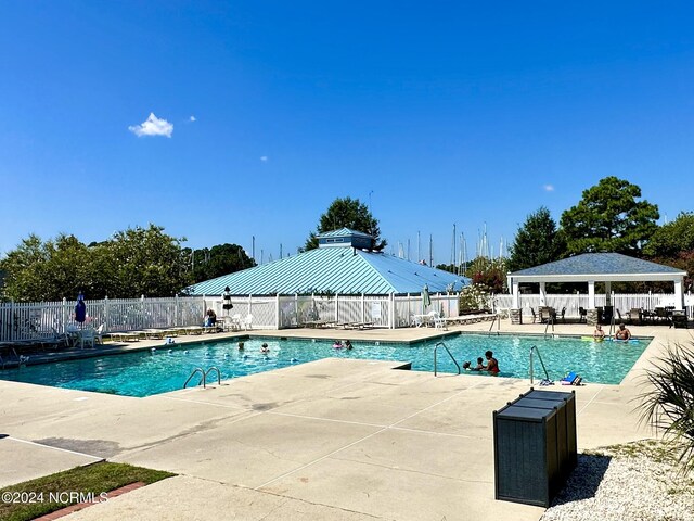 pool with a gazebo, a patio area, and fence