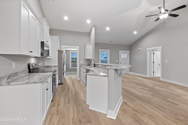 kitchen with lofted ceiling, light hardwood / wood-style floors, stainless steel appliances, and white cabinetry