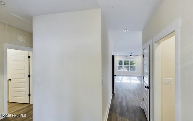 unfurnished dining area featuring dark wood-style flooring, visible vents, a notable chandelier, and baseboards