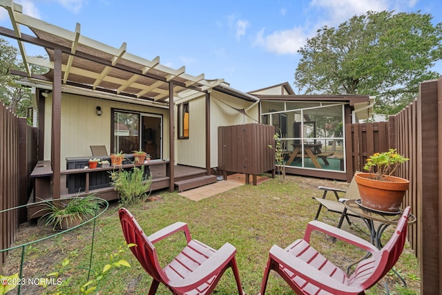 back of property featuring a deck, a sunroom, a pergola, and a lawn