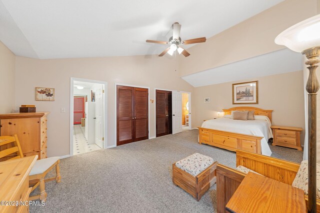 tiled bedroom featuring two closets, lofted ceiling, and ceiling fan