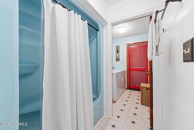 hallway with tile floors and washing machine and dryer