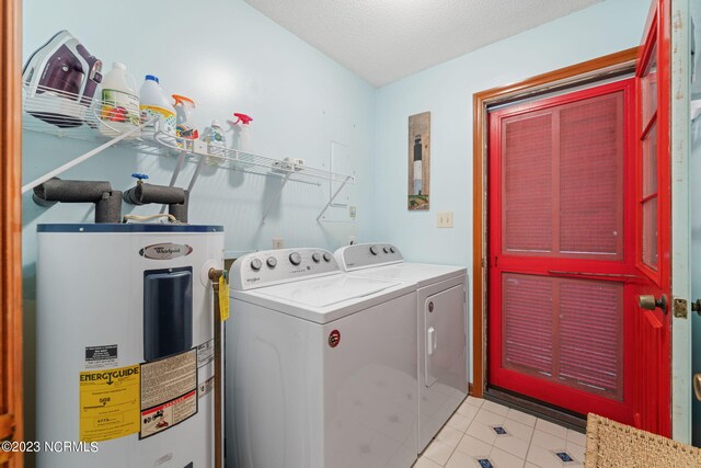 washroom featuring light tile flooring, washing machine and clothes dryer, washer hookup, a textured ceiling, and electric water heater