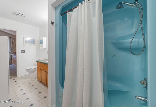 full bathroom with vanity, toilet, tile floors, and shower / tub combo