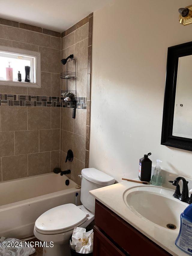 full bathroom with vanity, toilet, and tiled shower / bath