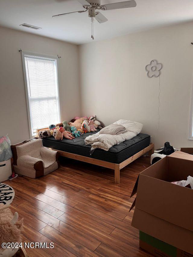 bedroom with ceiling fan and dark hardwood / wood-style flooring