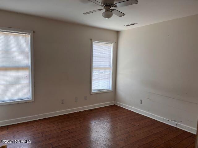 spare room with ceiling fan and dark hardwood / wood-style flooring