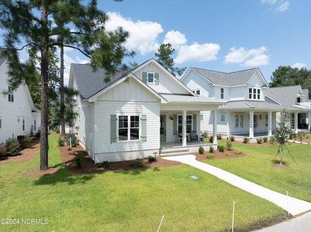 view of front of property featuring a porch, a front lawn, and central air condition unit