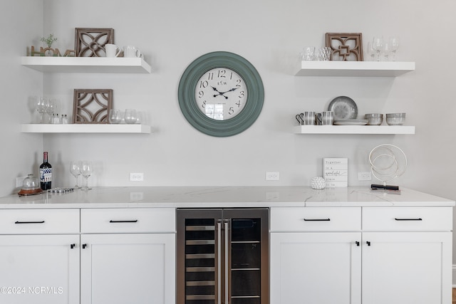 bar featuring white cabinetry, wine cooler, and light stone countertops