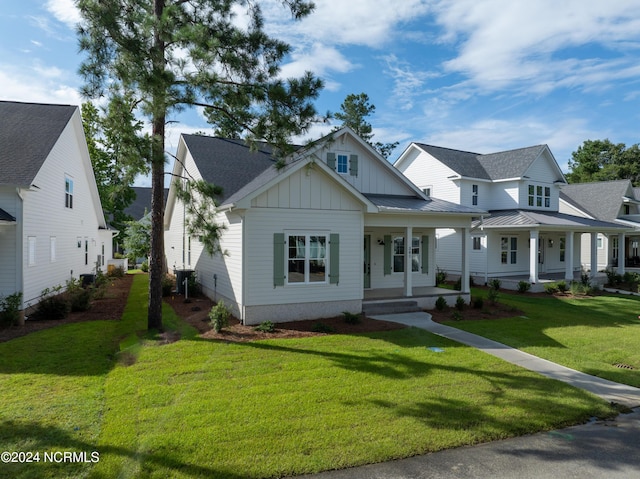 view of front of property with a porch, metal roof, a standing seam roof, a front lawn, and board and batten siding