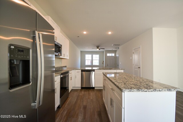 kitchen with a center island, ceiling fan with notable chandelier, sink, hanging light fixtures, and appliances with stainless steel finishes