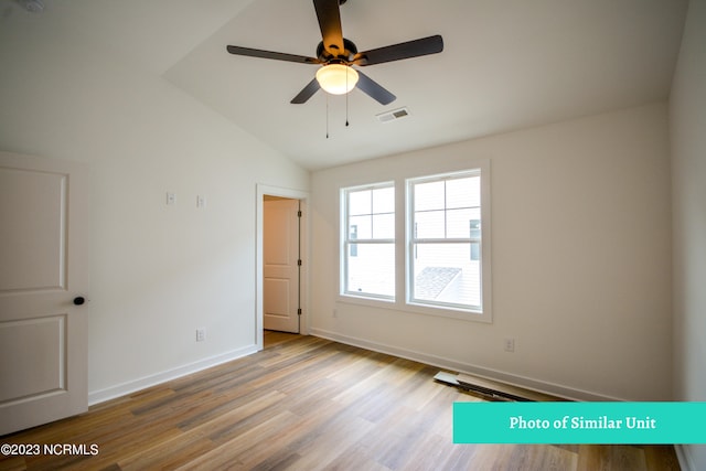 spare room with ceiling fan, light hardwood / wood-style floors, and vaulted ceiling