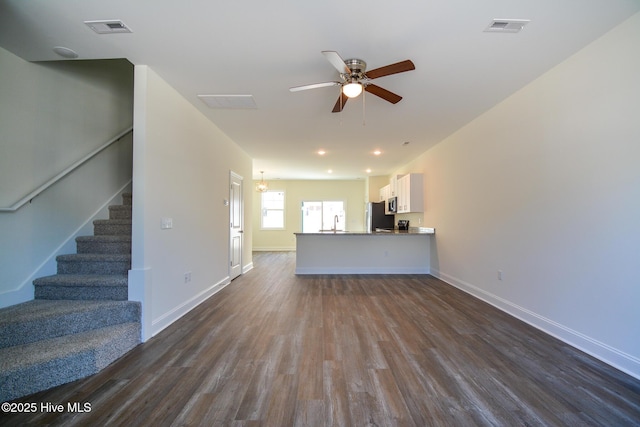 unfurnished living room with dark hardwood / wood-style flooring, sink, and ceiling fan