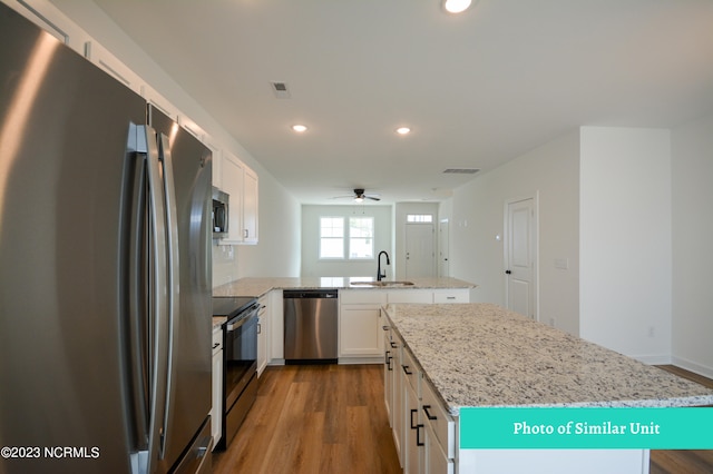 kitchen featuring a center island, white cabinets, stainless steel appliances, and sink