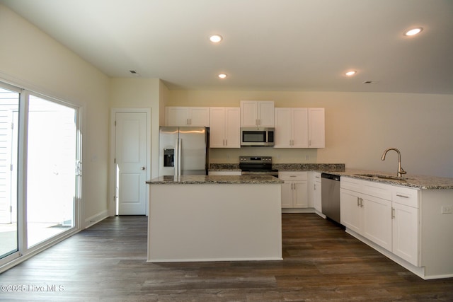 kitchen featuring sink, white cabinetry, stone counters, a wealth of natural light, and stainless steel appliances