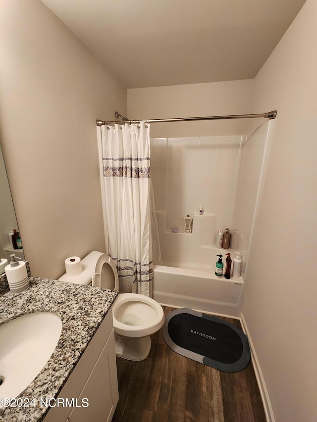 full bathroom with hardwood / wood-style flooring, shower / bath combo, vanity, and toilet