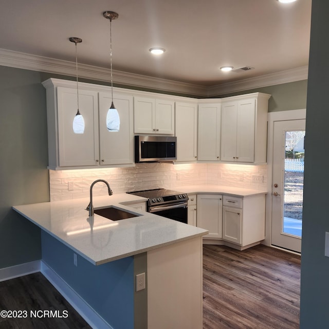 kitchen with sink, appliances with stainless steel finishes, white cabinetry, decorative light fixtures, and kitchen peninsula