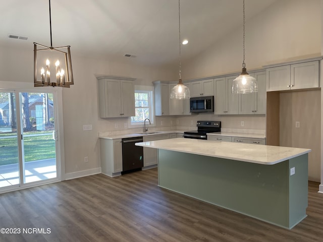 kitchen featuring black appliances, visible vents, a sink, and a center island