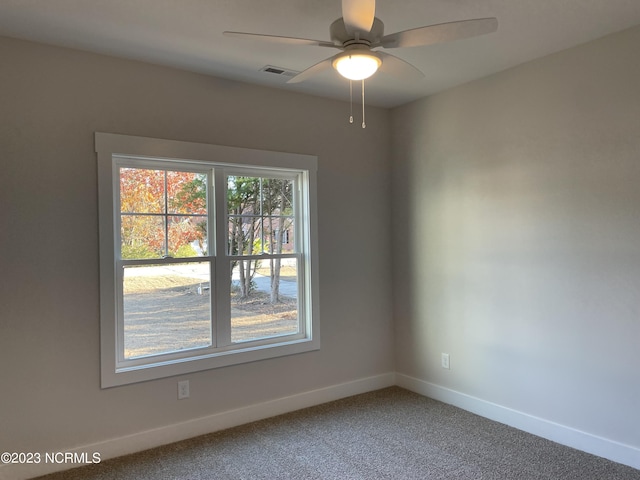 empty room featuring ceiling fan, carpet floors, visible vents, and baseboards