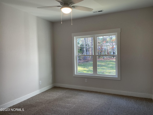 empty room featuring ceiling fan, carpet flooring, visible vents, and baseboards