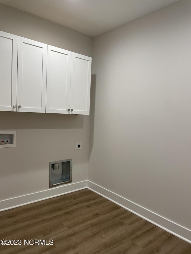 clothes washing area featuring cabinet space, baseboards, dark wood-type flooring, hookup for a washing machine, and hookup for an electric dryer