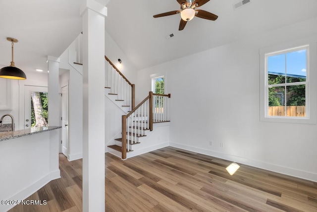 stairway featuring lofted ceiling, ceiling fan, and hardwood / wood-style floors