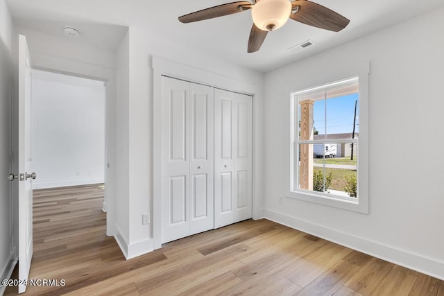 unfurnished bedroom with light wood-type flooring, a closet, and ceiling fan