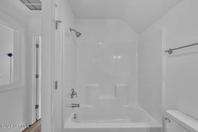 bathroom with toilet, wood-type flooring, and shower / bathing tub combination