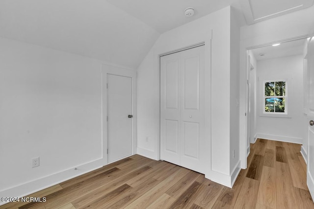 bedroom featuring vaulted ceiling, a closet, and light wood-type flooring