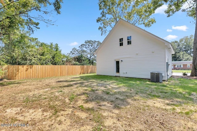 back of house featuring a lawn and central AC