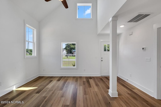 interior space featuring beamed ceiling, decorative columns, high vaulted ceiling, hardwood / wood-style flooring, and ceiling fan