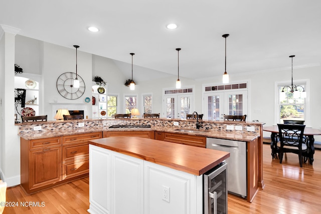 kitchen featuring beverage cooler, a center island, sink, french doors, and pendant lighting