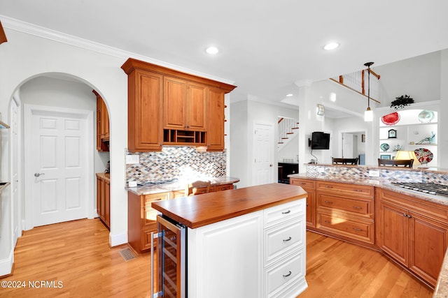 kitchen featuring a center island, wine cooler, tasteful backsplash, light hardwood / wood-style flooring, and pendant lighting