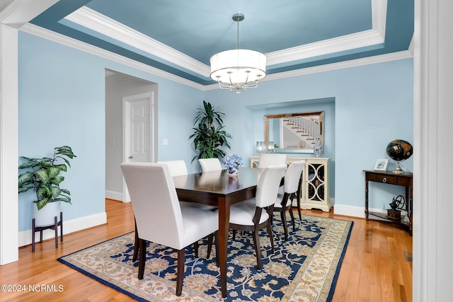 dining room featuring light hardwood / wood-style floors and a raised ceiling