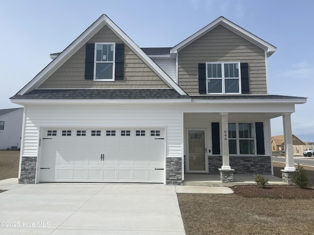 craftsman-style home featuring concrete driveway, a garage, covered porch, and stone siding