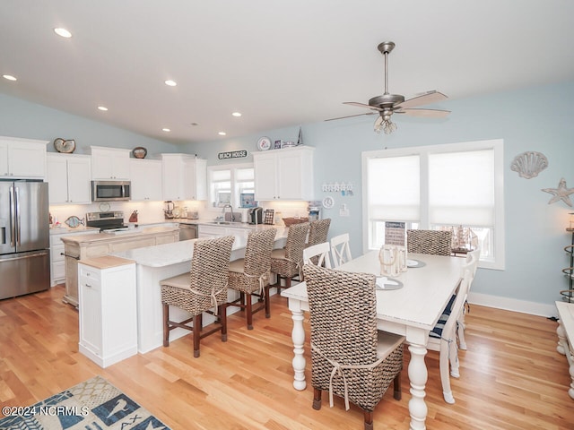 dining space with vaulted ceiling, light wood finished floors, baseboards, and recessed lighting