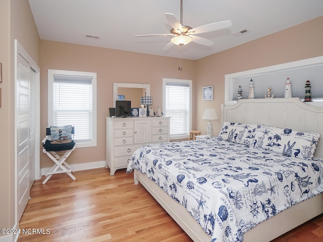 bedroom with light wood-style flooring, multiple windows, and visible vents